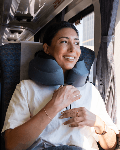 Woman using a travel neck pillow on a train