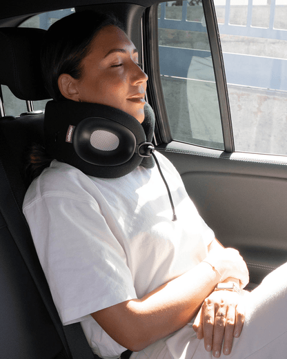 Woman in car sleeping comfortably wearing Evolution X Neck Pillow