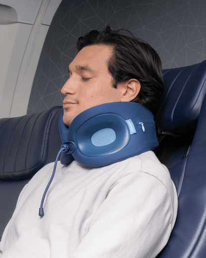 Man using a blue travel neck pillow in an airplane seat