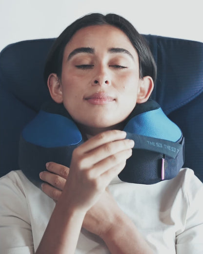 Pulling chin strap up, over, and across the neck pillow to secure and comfortable rest chin on
